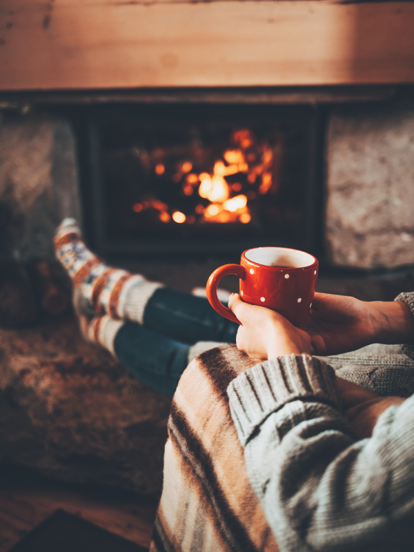 Person Holding Mug, Lounging by Fireplace